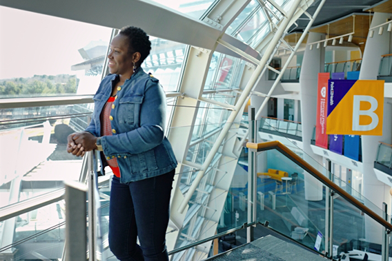 Point32Health employee on a staircase looking out a wall of glass