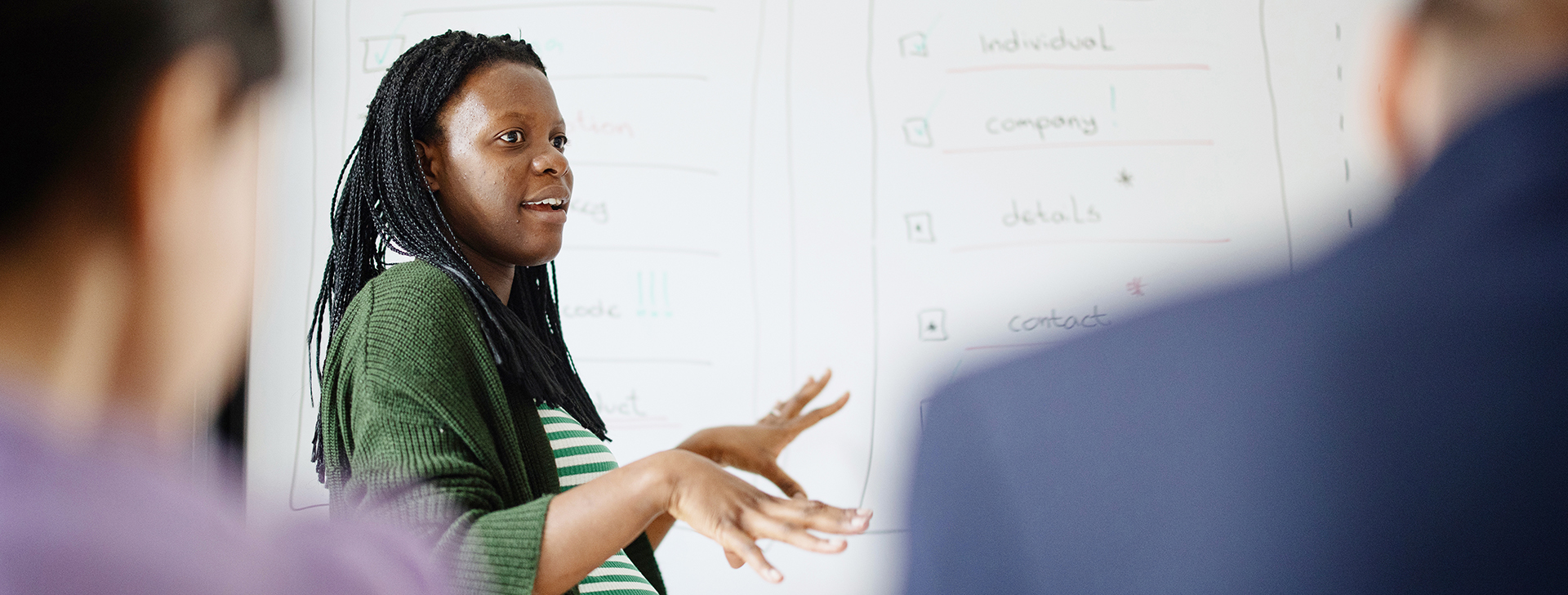 pregnant woman presenting to a group of colleagues in conference room